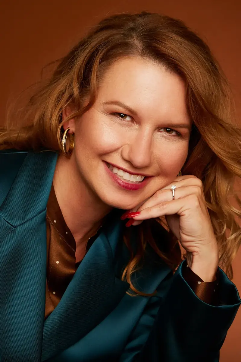 Portrait of Kara A. Nyquist resting her chin on her hand and smiling
